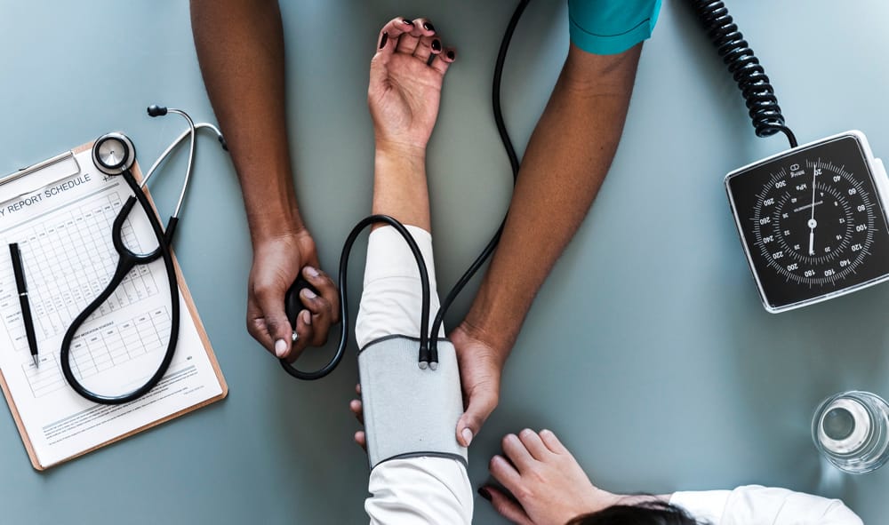 Les bras d'un médecin en train de prendre la pression d'un patient et de faire un examen de danté dans un complexe santé de boucherville