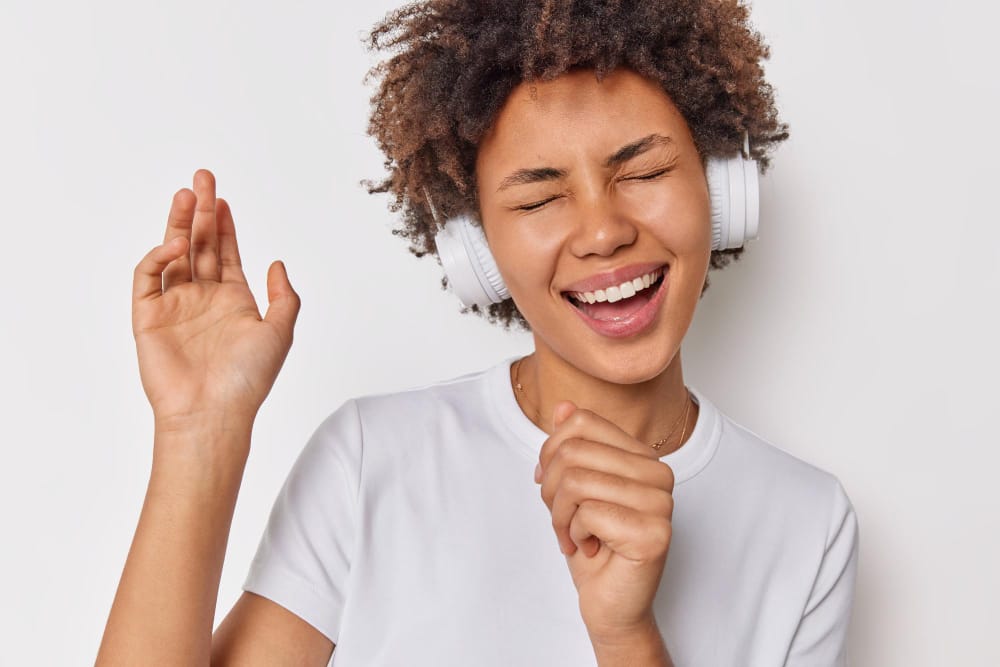 Jeune femme écoutant de la musique via une paire d'écouteurs.