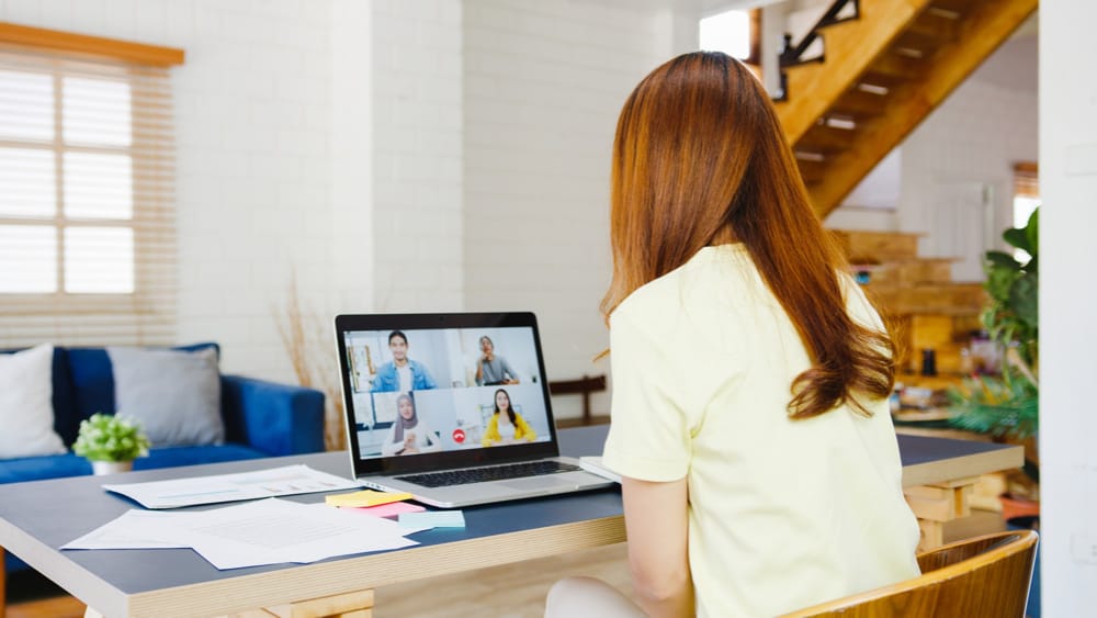 femme de dos travaillant de la maison sur un portable